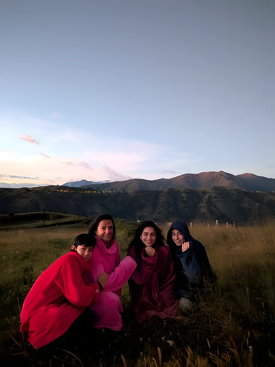 Familia con prendas K'priletto de colores en la montaña al atardecer